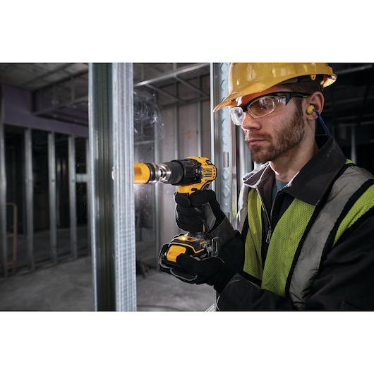 Atomic cordless compact half inch hammer drill driver being used by a person.