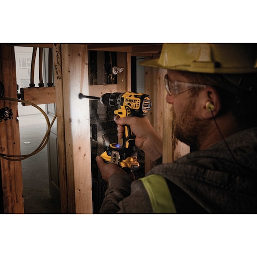 XR Cordless Compact drill driver with Tool Connect being used by a person to drill  wooden plank.
