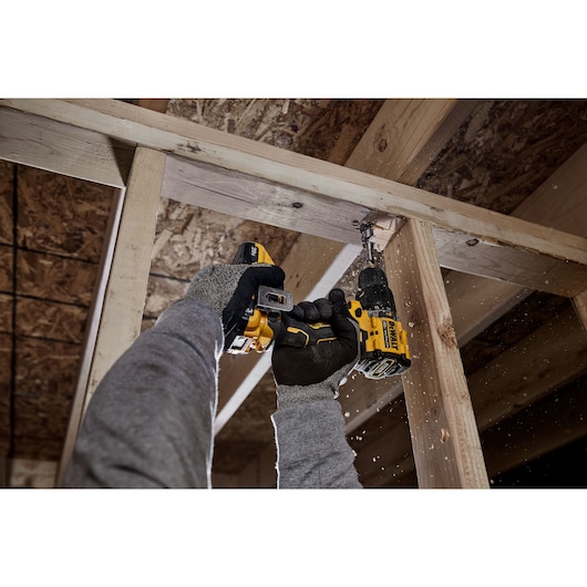 ATOMIC COMPACT SERIES(™) 20V MAX Brushless Hammer Drill drilling into wood framing