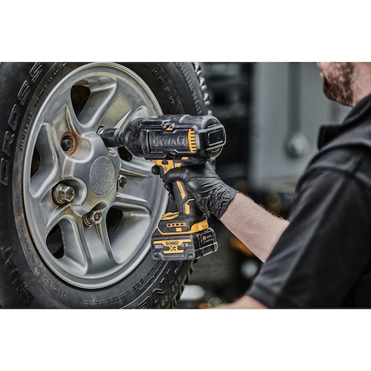 Impact Wrench removing lug nuts from a tire zoomed in, angled view