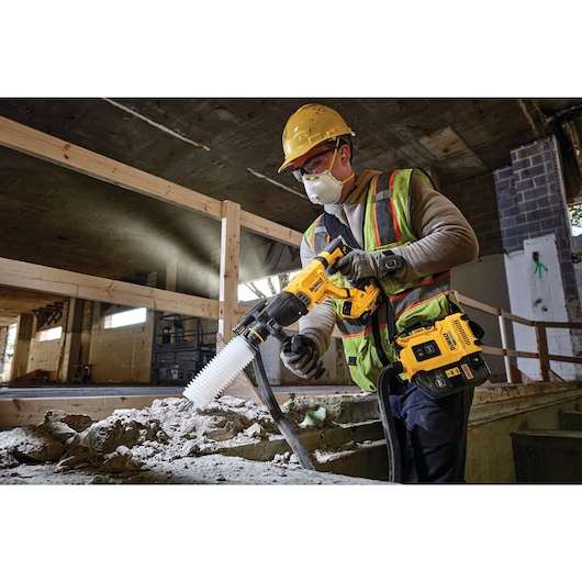 Brushless, cordless SDS PLUS D-Handle rotary hammer being used by a person