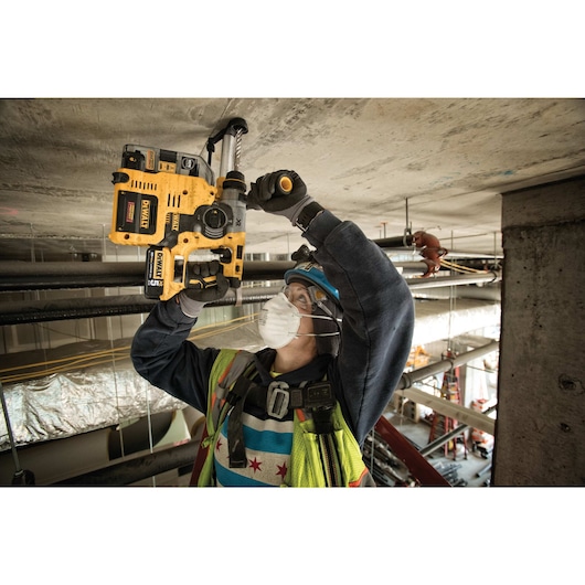 Brushless L-Shape SDS Plus rotary hammer with on-board dust extractor being used by a person