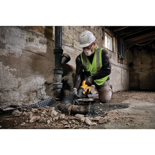FLEXVOLT® Brushless Cordless Reciprocating Saw Kit being used by worker to cut metal pipe at worksite