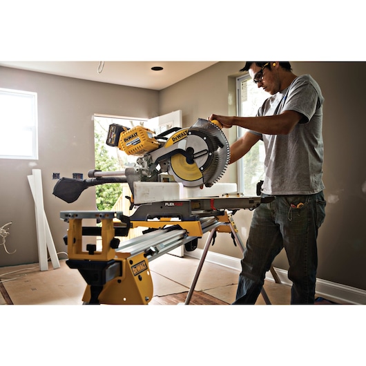FLEXVOLT cordless, double bevel compound sliding miter saw being used by a person