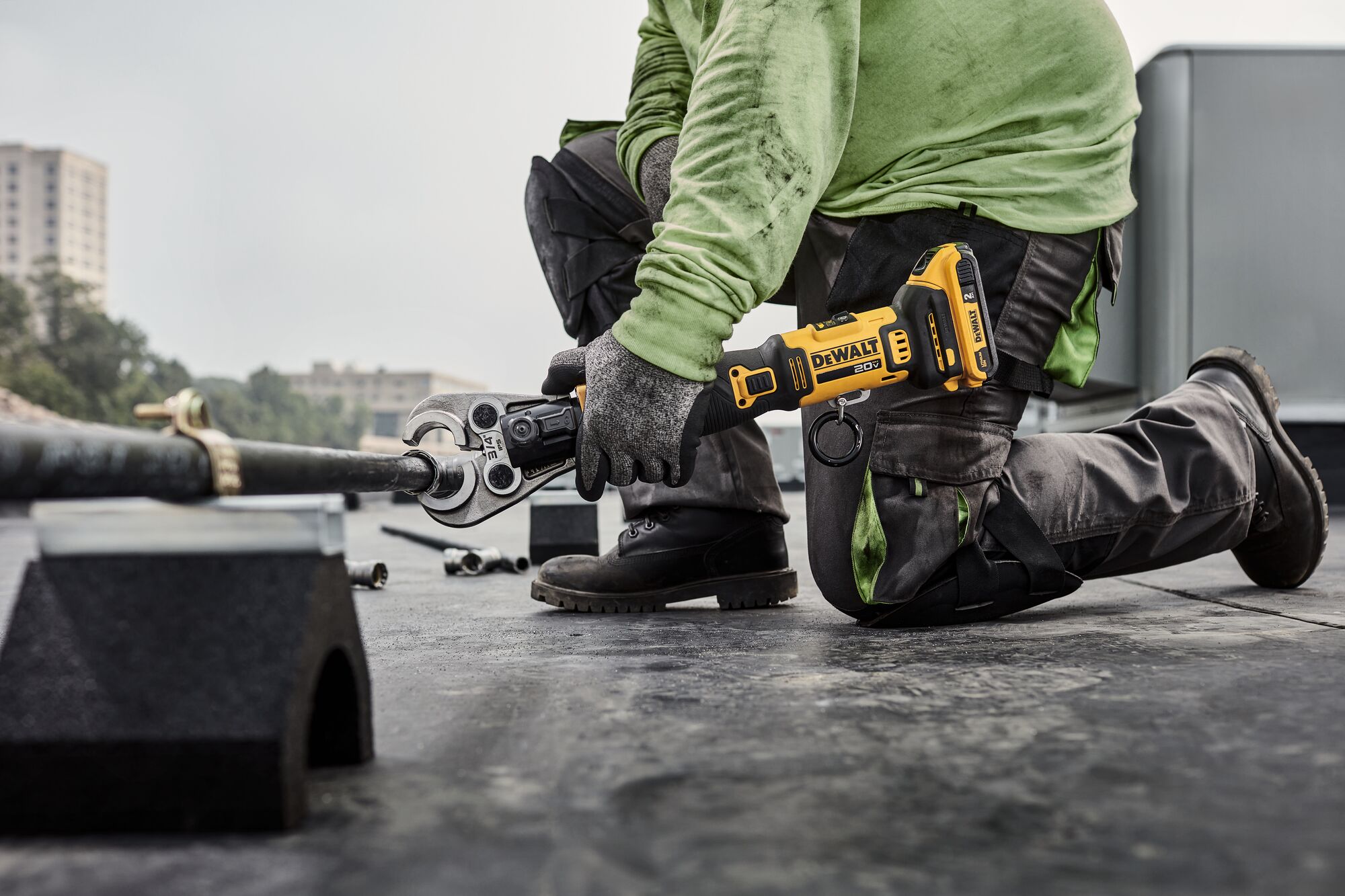 DEWALT Compact Press Tool getting ready to press black iron pipe on a rooftop.
