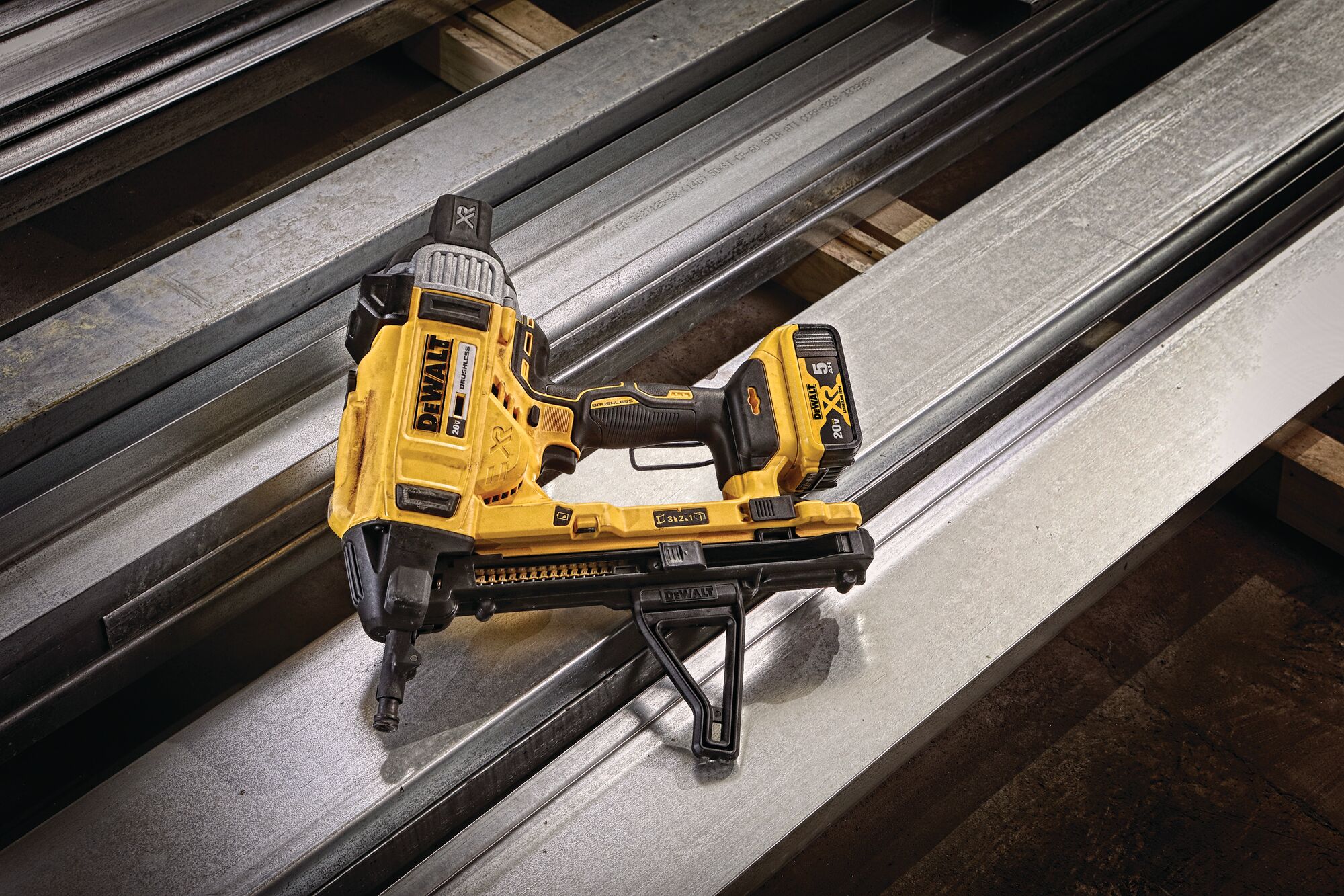 Magazine Cordless Concrete Nailer with a battery placed on drywall tracks.