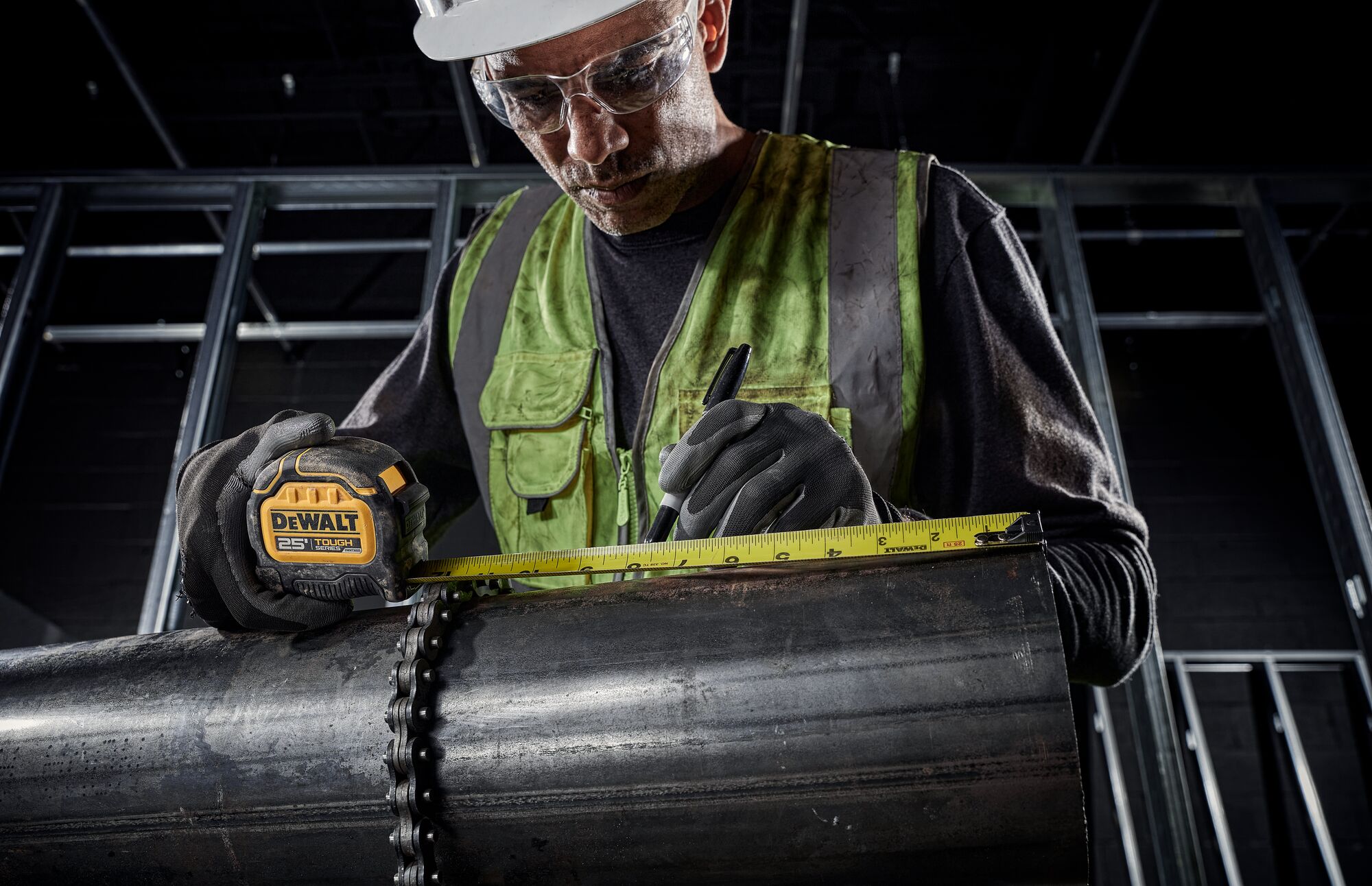 Tough Series 25 feet Tape Measure being used by worker to measure metal pipe at worksite.