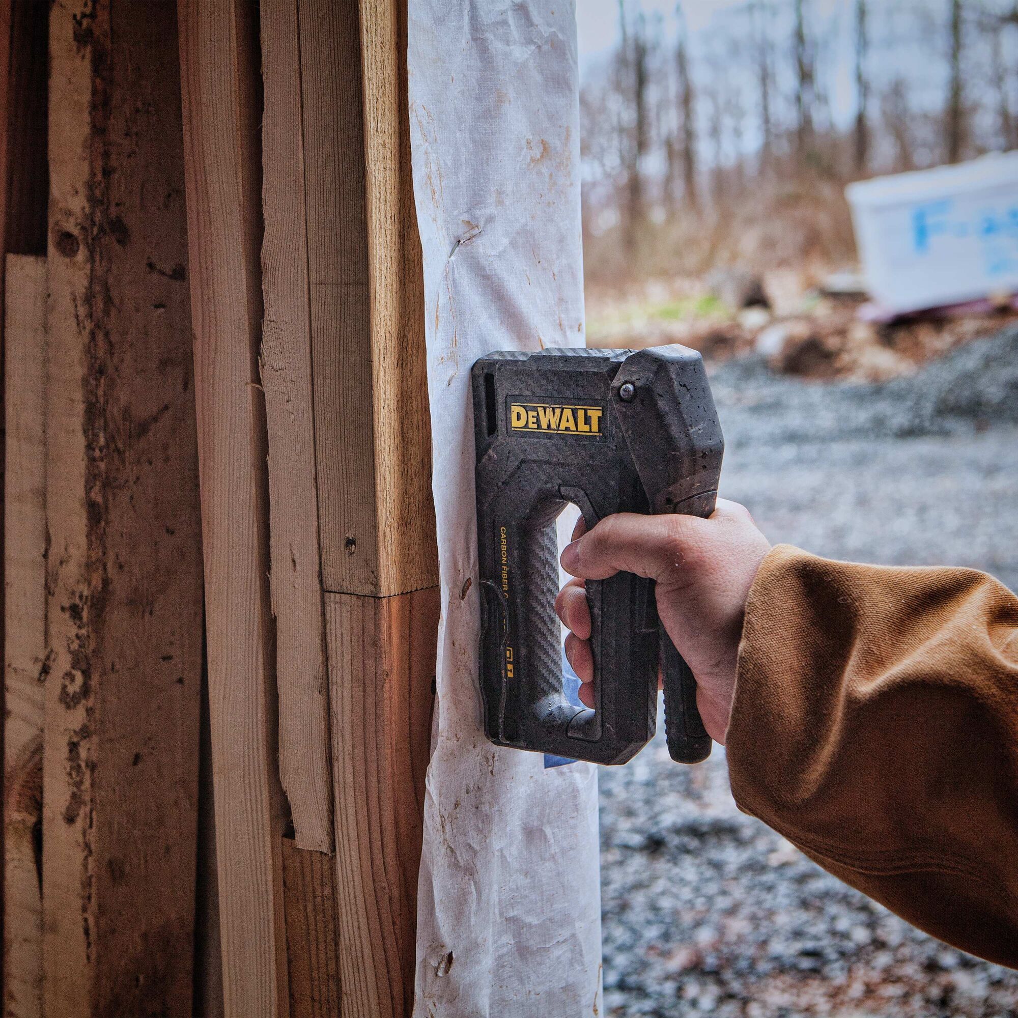 Carbon Fiber Composite Staple Gun being used to staple underlay on  wall outside.