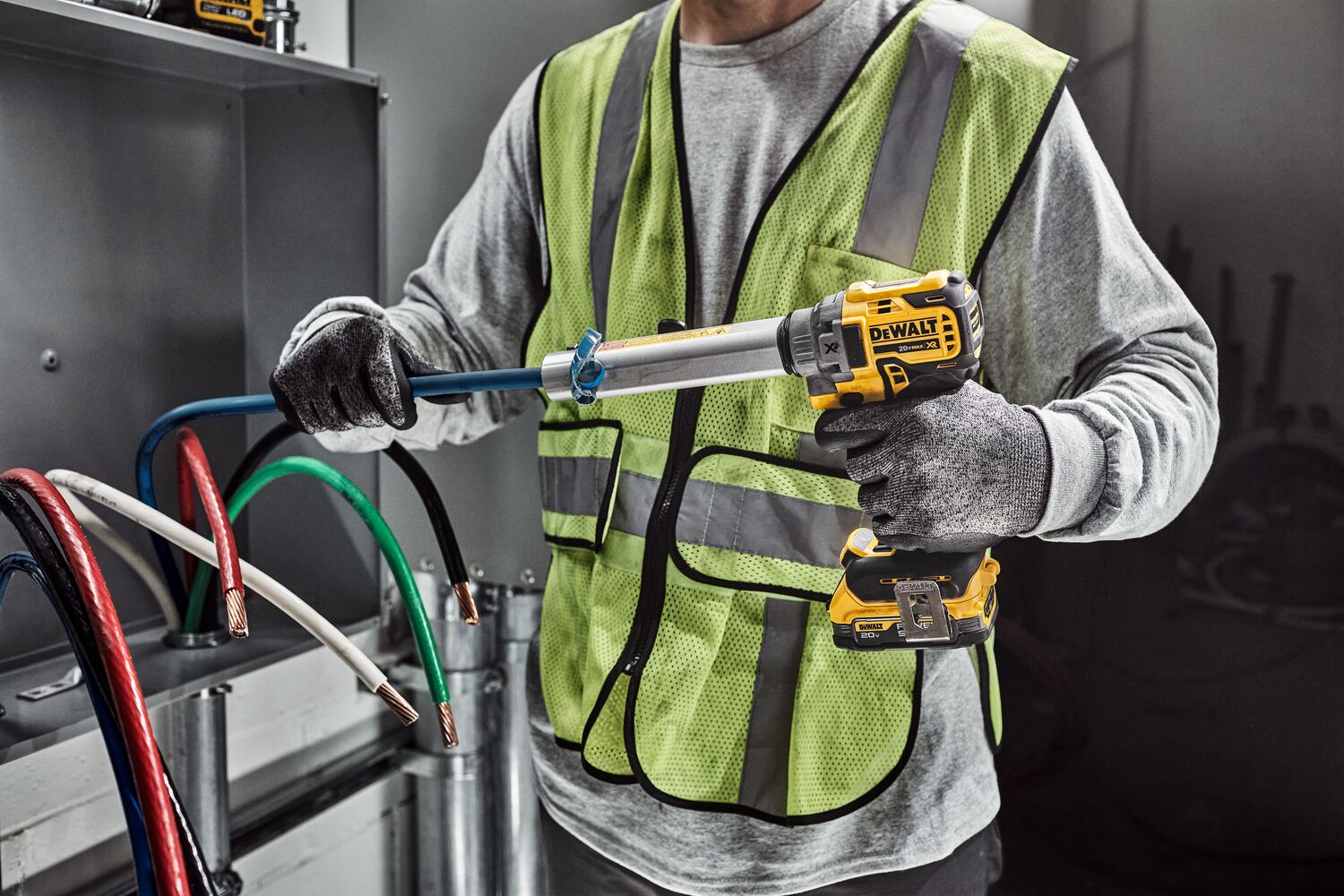 DEWALT Cable Stripper is used to strip a blue cable by a tradesman in an electrical room.