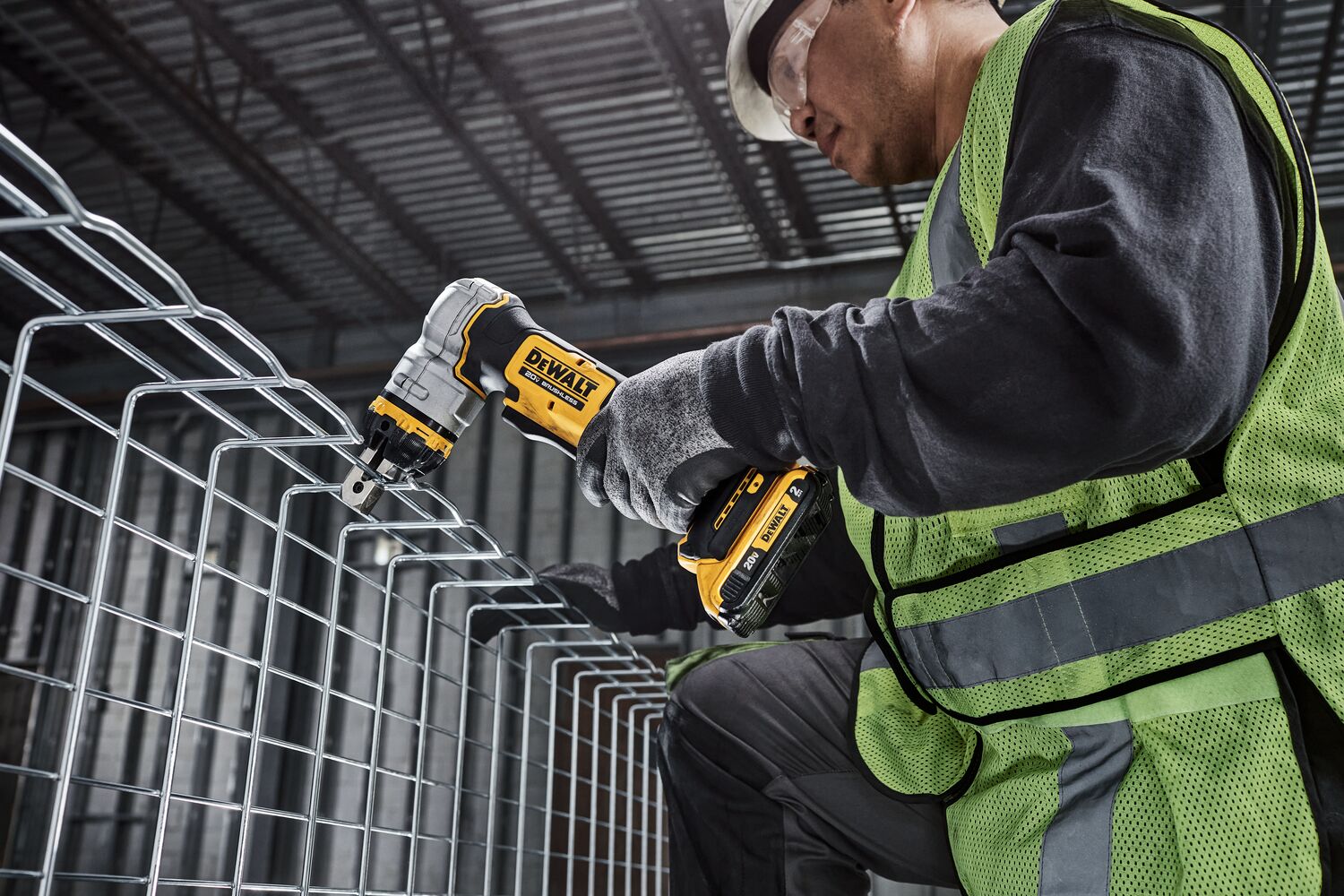 DEWALT Cable Tray Cutter is used by a kneeling tradesman to cut basket tray in a data center.
