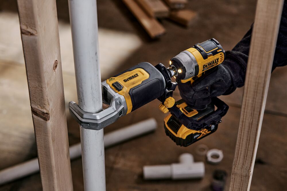 End user using DEWALT IMPACT CONNECT PVC/Pex Cutter attachment on Impact Driver to cut PVC pipe next to wood beam