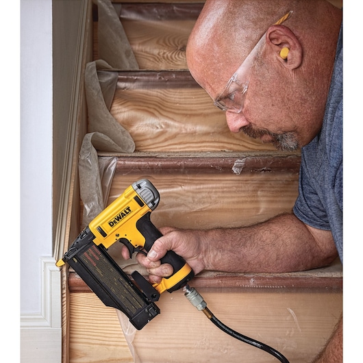 Close up of 23 gauge pin nailer being used by a person to fasten nails.