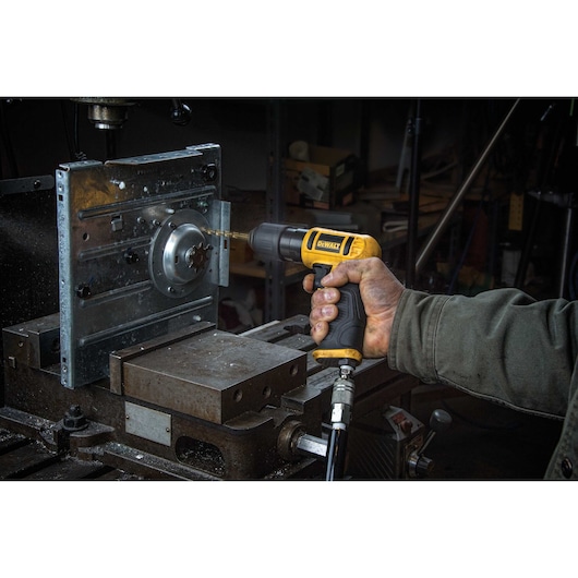 DEWALT reversible drill being used by a person indoors.
